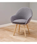 Gray chair on wooden floor showcasing Heavy Duty Self Adhesive Gripping Pads For Hard Surfaces One And A Half Inch Brown 8 Count No Slip Furniture Grippers That Keep Appliances And Lamps From Dancing And Staying Put On Floors And Tables.