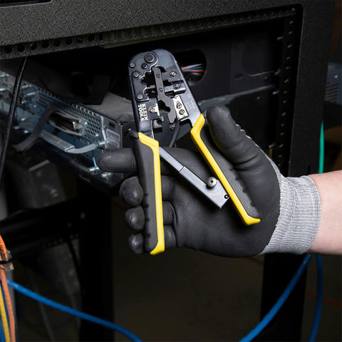 Person using Ratcheting Go-To Modular Crimping And Wire Stripping Tool For RJ22 RJ11 RJ12 RJ45 Connectors near network rack.