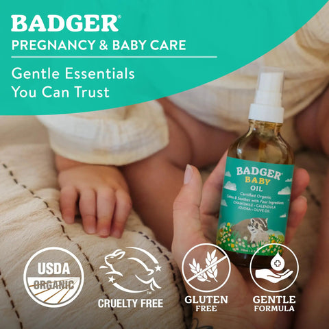 Organic Baby Oil With 5 Simple Ingredients To Soften Dry Skin And Cradle Cap, 4 Fl Oz Glass Bottle in hand near baby's feet