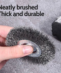 Hand holding coarse bristle from 18Piece Wire Wheel Cup Brush Set For Drills With One Quarter Inch Hex Shank, gray background