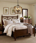 Farmhouse Style Chandelier Light Fixture For Kitchen And Dining Room With Barn Chic Vibe hanging above a rustic bedroom setting.