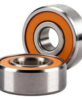 Two stainless steel hybrid ceramic ball bearings with orange seals, front view.