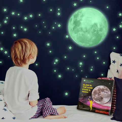 Child admiring glow in the dark ceiling stars and moon wall decals for kids bedroom or nursery, self adhesive luminous night sky stickers.