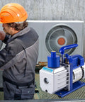 Heavy Duty 4.8 CFM 1/3 HP Auto AC Vacuum Pump With Integrated Manifold And Anti Reflex Oil Solid Die Cast Housing positioned near technician.