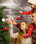 Family decorating tree with Three Pack Totally Vintage Red Truck Christmas Ornaments With Mini Christmas Trees.