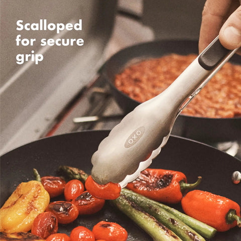 Outdoor Camp Stove Cooking Set With Silicone Utensil Rest Silicone Turner Silicone Spoon And 10.5 Inch Stainless Steel Tongs gripping vegetables on a grill.