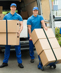 Two delivery men with 8 Pack 80 Inch Adjustable Flat Bungee Cords securing boxes to dolly and trolley by van