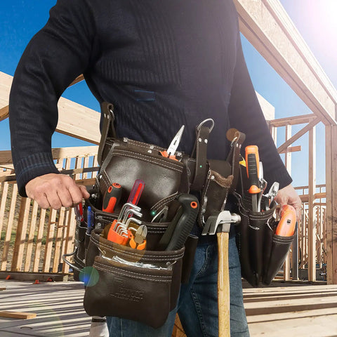 Person wearing Premium Grain Leather Tool Belt With 19 Pockets And Padded Belt Carpenter Rig Set Hammer Holders Electrician Bag Construction Framing Pouch In Chocolate at a construction site.