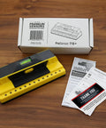 ProSensor 710 Plus Stud Finder With 13 Sensors, bubble level, packaging box, and instruction guides on wooden table