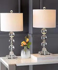 Fiona Crystal Stacked Ball 24 Inch Table Lamp Set Of 2 with lamps placed on modern desk, lit crystal glow, vase with flowers, and book