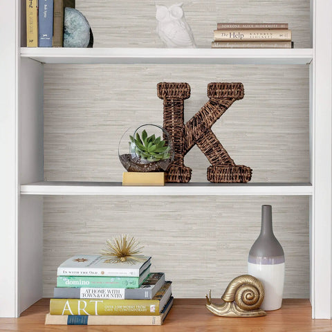 Bookshelf with decor and cream vinyl grassweave peel and stick wallpaper for easy DIY accent walls repositionable and no mess
