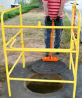 Person using Compact Magnetic Lid Lifter That Cracks Open Tough Manhole Covers Without Breaking A Sweat While Hauling Up To 150 Pounds Thanks To Strong Neodymium Magnets And Solid Aluminum Frame In Orange to lift a manhole cover.