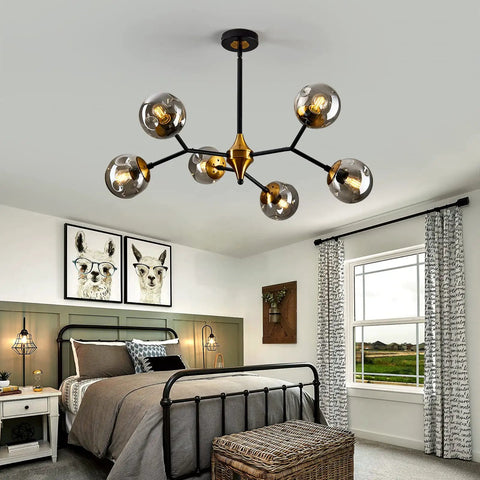 Six Light Glass Globe Chandelier with adjustable boom in gold and black over a modern bedroom, highlighting design and function.