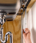 Fold Over Basin Adjustable Pipe Wrench 10 To 17 Inch Telescoping Shank in use under sink with one hand ratcheting grip