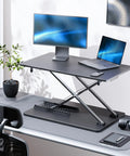 Ergonomic Standing Desk Converter With Quick Height Adjustment, 25.16 Inch Wide By 15.75 Inch Deep, Sit Stand Laptop And Monitor Stand, No Assembly Required, No Fuss Setup For Home Office And Desk Use, Black on office desk with monitor and laptop