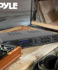 Bluetooth 5.1 Home Theater And Karaoke Amplifier That Delivers Party Ready Big Room Sound With Five Channels And Subwoofer Output Two Mic Inputs With Echo USB A Plus SD MP3 Player RCA In PDA8BU on wooden shelf
