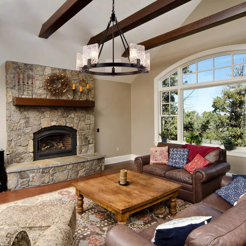 Living room with 5 Light Black Farmhouse Chandelier for Dining Room and Foyer hanging from wood beams, rustic decor, stone fireplace.