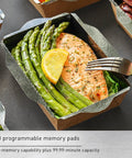 Salmon fillet with asparagus and lemon served in a paper tray, with a fork on the side, ready for microwave heating demonstration.