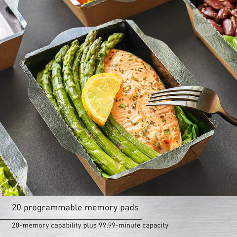 Salmon fillet with asparagus and lemon served in a paper tray, with a fork on the side, ready for microwave heating demonstration.