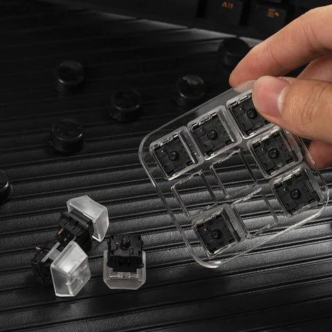 Hand holding Nine Key Cherry MX Switch Tester For Mechanical Keyboards with nine distinct switches on clear acrylic base.