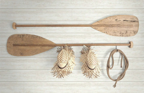 White Shiplap Peel and Stick Wallpaper Roll, DIY Friendly featuring decorative wooden oars, hats, and rope against the wallpaper.