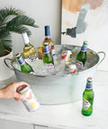 Large Galvanized Ice Tub For Parties With Sturdy Handles Six Point Three Gallon Beverage Cooler For Beer Wine Soda And Bottled Water Rustic Indoor Outdoor Drink Bucket displayed on a counter with drinks inside.