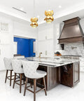Modern kitchen with white cabinets, marble island, and bronze range hood, elegant interior design with luxurious details