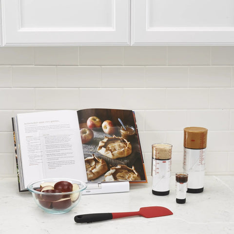 Two Cup Adjustable Measuring Cup with Grippy Rotating Body displayed on kitchen counter with apple galette recipe book