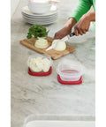 Easy Find Lids Food Storage Containers 1.25 Cup Set In Racer Red, 4 Piece Nesting Storage Set on countertop with chopped onions