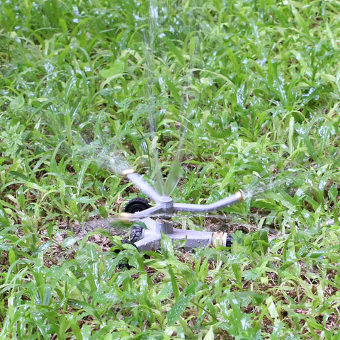 Heavy Duty Metal 3-Arm Rotating Sprinkler With Wheeled Base, 360 Degree Lawn Sprinkler For Small Yards in operation on grass