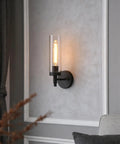 Matte Black Rustic Industrial Wall Sconce Light With Tubular Clear Glass Lampshade on gray wall in living room