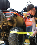 Man using Heavy Duty Car Tie Down Straps With Flat Hooks 10000 Lb Break Strength 4 Pack Tire Ratchet Straps For Trailers Trucks And UTVs 10Ft Lasso Straps Fit All Size Tires Smooth D Ring Hooks For Easy Mounts On Side Rails on ATV tire.