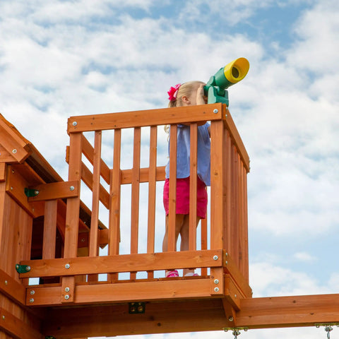 Child using telescope on Skyfort II Cedar Wood Swing Set With Wave Slide, Raised Clubhouse, Crow's Nest, Monkey Bars, Balcony