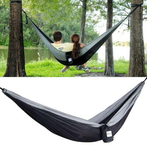 Parachute Nylon Hammock Single With 2 Tree Straps set between trees near a lake, showing lightweight camp gear for outdoor use.