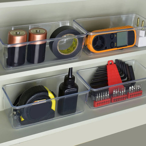 Clear Drawer Organizer Set Of 4 Pieces For Office, Home, Kitchen And Makeup Storage, Grab And Go Crystal Clear Plastic Modular Box Trays For Junk Drawers, Easy To See And Use, Each Measures 6.25 X 3.13 X 2.13 Inches containing batteries and tools.