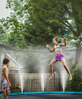 Children playing on a trampoline with Misting System 26 Foot Kit With Brass Nozzles And Three Quarter Inch Brass Adapter for cooling.