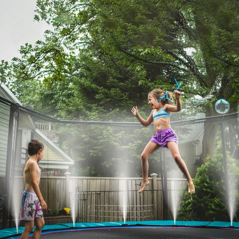 Children playing on a trampoline with Misting System 26 Foot Kit With Brass Nozzles And Three Quarter Inch Brass Adapter for cooling.