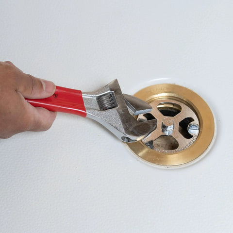 No Calk Shower Drain Wrench with brass and plastic construction used on a stainless steel drain