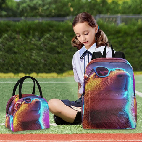 Child sitting on grass with colorful neon bear design backpack and lunch bag, both featuring sunglasses-wearing bear print.