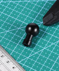Durable Aluminum 17mm Ball Head Mount With A One Quarter Inch Twenty Screw on grid surface with ruler and tool