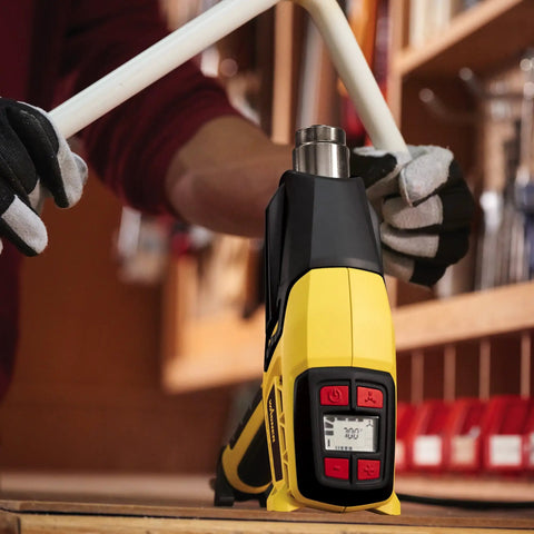 Person using FURNO 700 Digital Heat Gun with 2 nozzles and adjustable 125 to 1300 F temperature for bending PVC pipe
