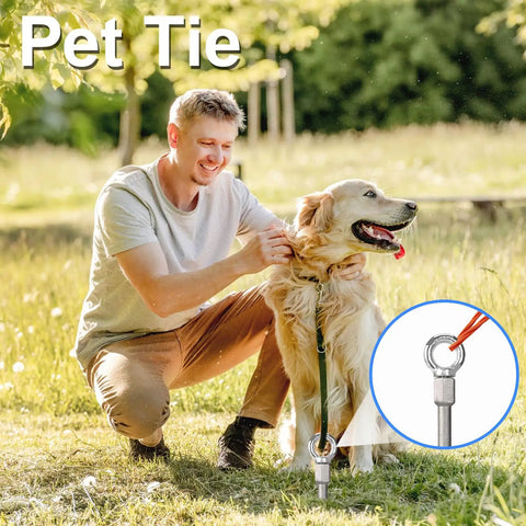 Man securing a pet tie to the ground with a smiling dog outdoors.