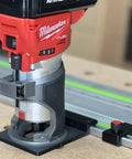 Milwaukee Router fitted with Solid As A Rock Guide Rail Adapter for precise track saw setup on workshop table.