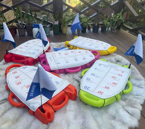 Spearfishing Float Buoy With Foldable Carbon Fiber Flagpole and D Ring Handles in orange, red, yellow, green on a deck