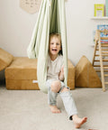 Child in Ultimate Chill Cotton Sensory Cocoon Swing For Kids Autism And Adhd Therapy Support Indoor Outdoor Hammock Desert Sage.