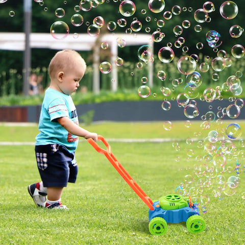 Toddler playing with Bubble Lawn Mower Toy With Realistic Sounds And Bubble Maker For Toddlers in grassy garden