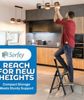 Man using Two Step Folding Ladder With Bamboo And Black Aluminum in kitchen to change light bulb, showcasing ultra slim profile and stability.