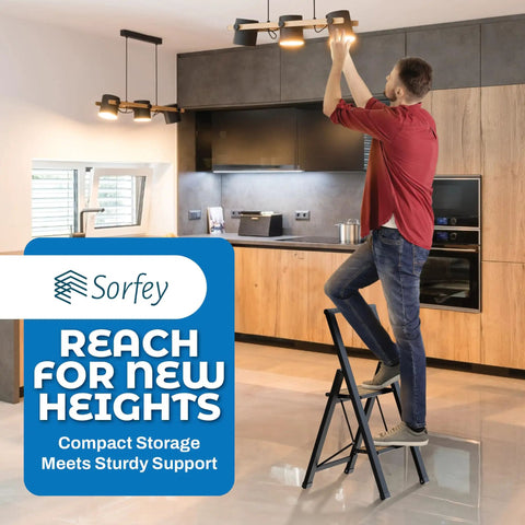 Man using Two Step Folding Ladder With Bamboo And Black Aluminum in kitchen to change light bulb, showcasing ultra slim profile and stability.