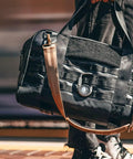 Person carrying a bag with Upgraded AirTag Link And Lock With Heavy Duty 3 Digit Combination Lock Secure Polycarbonate Housing