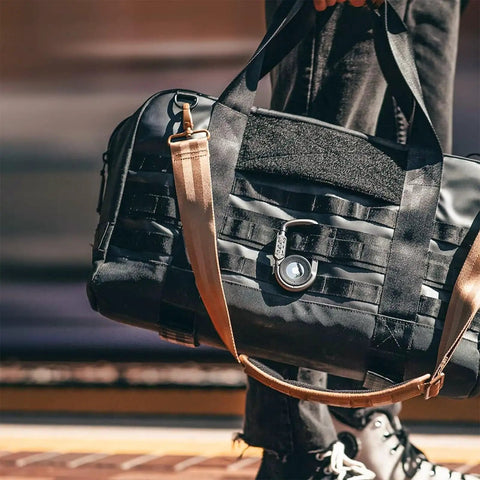 Person carrying a bag with Upgraded AirTag Link And Lock With Heavy Duty 3 Digit Combination Lock Secure Polycarbonate Housing